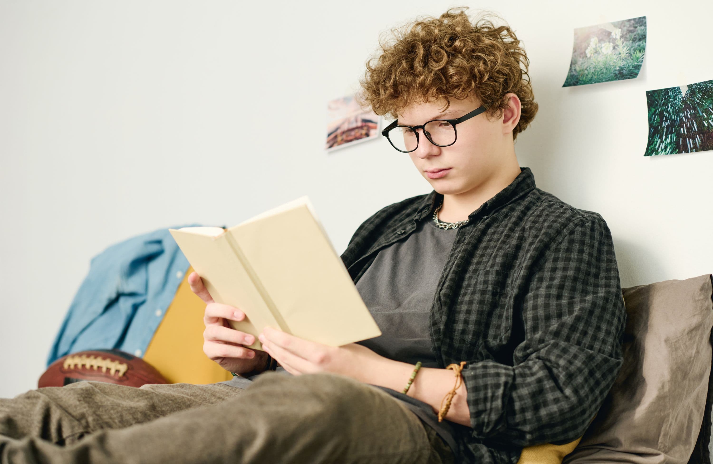 serious-teenage-guy-eyeglasses-casualwear-reading-book